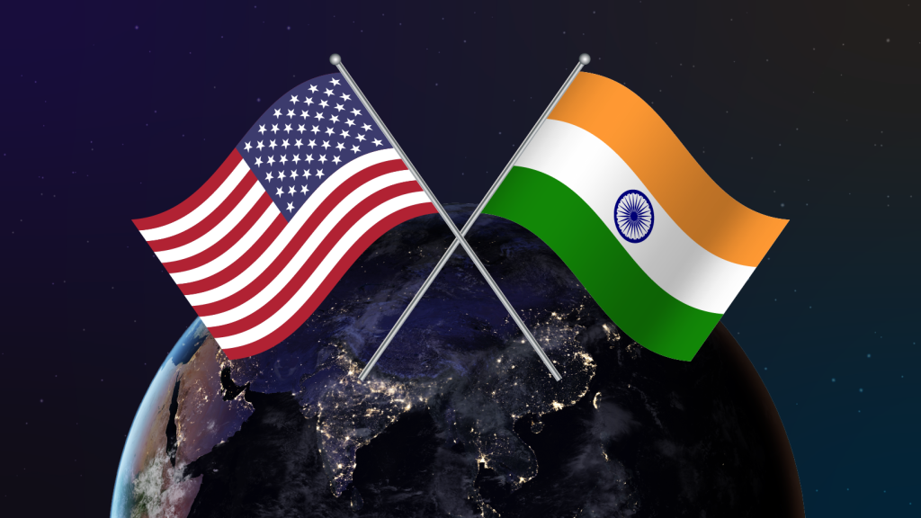 Crossed flags of the United States and India over a nighttime Earth