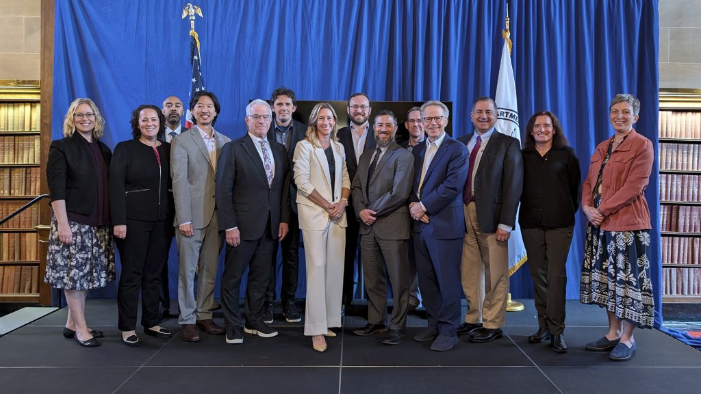 The Advisory Committee on Excellence in Space (ACES) group standing in front of a blue back drop