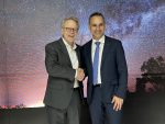 Richard DalBello (left) shakes hands with Enrico Palermo in front of a starry night backdrop