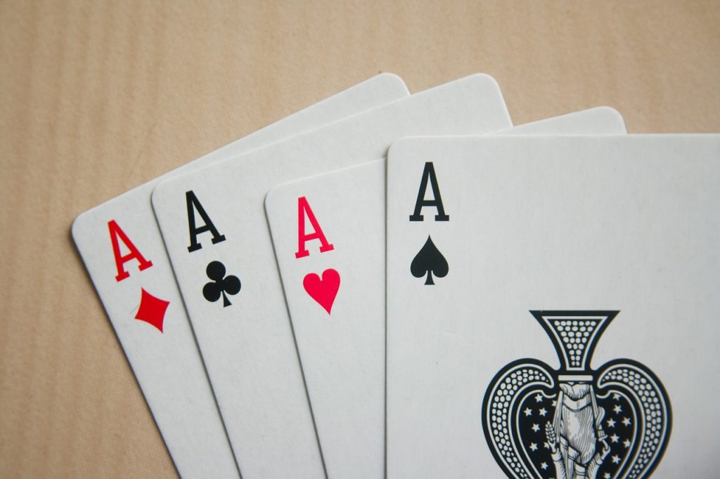 Fan of 4 playing card aces on a table